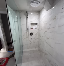 modern-bathroom-shower-white-marble-tile Modern bathroom shower with glass enclosure and white marble-style tile